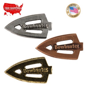 May include: Three arrowhead-shaped metal keychains in silver, copper, and gold. Each keychain features the word "Bowhunter" engraved on the front.