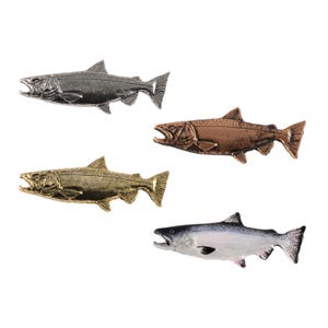May include: A set of four fish-shaped pins featuring detailed scales and fins. Three pins have metallic finishes in silver, copper, and gold tones, while the fourth pin is painted with realistic colors including a dark back and white belly.