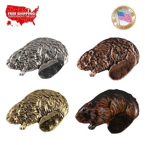 May include: Four different colored metal beaver figurines. The beaver figurines are in silver, copper, gold, and bronze. Each beaver is lying on its side with its tail curled up behind it. The beaver figurines are made in the USA with pride.