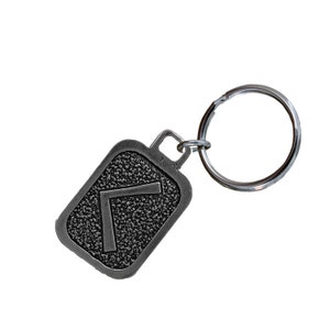 May include: A silver key chain with a rectangular tag featuring a raised, textured number seven.