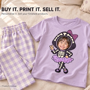 May include: A light purple short-sleeved t-shirt and light purple and white gingham pyjama trousers. The t-shirt features a graphic of a skeleton costume with a purple bow and a child's face. Text reads: BUY IT. PRINT IT. SELL IT. Personalise it.