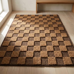 Puede incluir: Una alfombra rectangular con un patrón de tablero de ajedrez tridimensional en relieve. El diseño consta de cuadrados alternos en marrón oscuro y bronceado claro, con los cuadrados claros presentando un acabado texturizado.