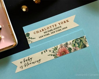 May include: Two white labels with a floral design and brown text. The top label reads "CHARLOTTE YORK 930 PARK AVENUE NEW YORK, NEW YORK 10028". The bottom label reads "a baby is blooming".