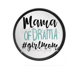 May include: A round patch with a white background and a black border. The text "Mama of Drama" is in black script, with "Drama" in teal. Below, the text reads "#girlmom" in black script.