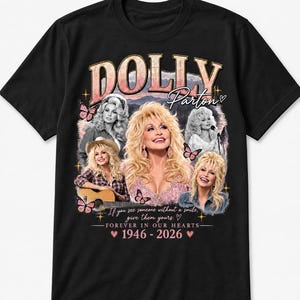 May include: A black t-shirt featuring a graphic print of Dolly Parton with multiple portraits, butterflies, and stars. The text reads DOLLY Parton, If you see someone without a smile, give them yours, FOREVER IN OUR HEARTS, and 1946 - 2026.