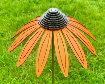 May include: Orange metal flower with a gray metal center, standing in a green grassy lawn.
