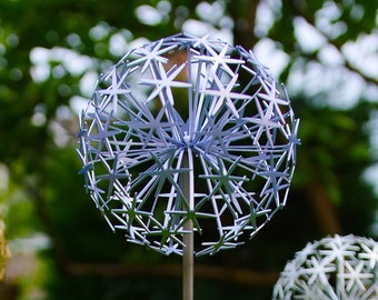 May include: Two metal garden ornaments shaped like a dandelion with a silver finish. The larger ornament is a light blue color and the smaller ornament is white.