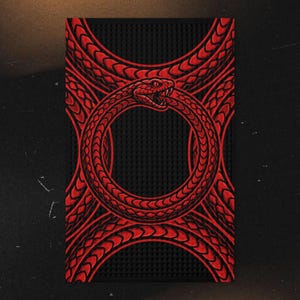 May include: A rectangular black bar mat featuring a vibrant red graphic of a snake coiled into a circular Ouroboros shape. The snake has detailed scales and an open mouth showing fangs. The background has a textured, grid-like pattern.