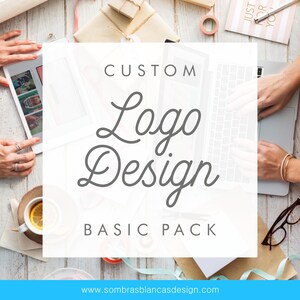 May include: A white square with the text "CUSTOM Logo Design BASIC PACK" and the website address "www.sombrasblancasdesign.com". The square is on a wooden surface with a laptop, a cup of tea, and other items.