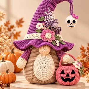 Pode incluir: Um gnomo de crochê usando um chapéu roxo alto decorado com uma teia de aranha branca, flores rosas e brancas, folhas verdes e uma pequena aranha roxa. Um crânio branco com um laço rosa pende da ponta do chapéu. O gnomo segura uma abóbora.