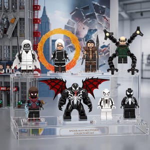 May include: A Spider-Man Multiverse collector's set featuring eight plastic minifigures displayed on a clear acrylic stand. The figures include characters with various accessories, wings, and mechanical arms, all arranged in two rows on the tiered base.