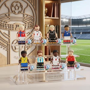 Può includere: Otto statuette in miniatura di calciatori con varie maglie nazionali e di club, ognuna abbinata a un piccolo pallone da calcio, esposte su un supporto in acrilico trasparente a tre livelli. Una targhetta frontale riporta CLUB LEGENDS COLLECTOR'S EDITION.