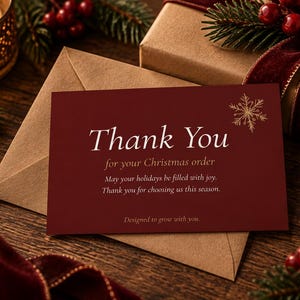 May include: A rectangular dark red card with white text that reads Thank You for your Christmas order, May your holidays be filled with joy. Thank you for choosing us this season. Designed to grow with you. A gold snowflake icon is in the corner.