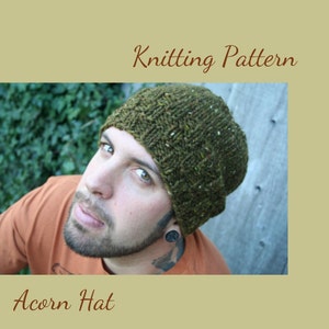 May include: A green knitted hat with a textured pattern. The hat is being worn by a person with a beard and a tattoo on their neck.