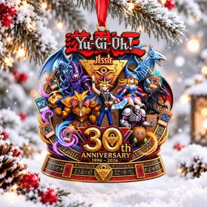 Pode incluir: Um ornamento do 30º aniversário de Yu-Gi-Oh! 1996-2026 com a personagem Jessie, vários monstros e cartas de jogo. O design circular inclui detalhes dourados, uma fita vermelha para pendurar e o logótipo oficial no topo.