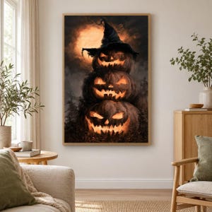 May include: A vertical wall art print featuring a stack of three glowing jack-o'-lanterns against a dark, moody background with a large, bright orange full moon. The top pumpkin wears a pointed witch hat, and all three have carved faces.