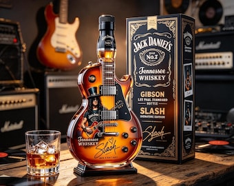 Puede incluir: Una botella de whisky Jack Daniel's Tennessee con forma de guitarra Gibson Les Paul, con un gráfico de la edición firmada por Slash. La botella muestra el texto 'Jack Daniel's', 'Tennessee Whiskey', 'Gibson Les Paul Standard Bottle' y 'Slash'.
