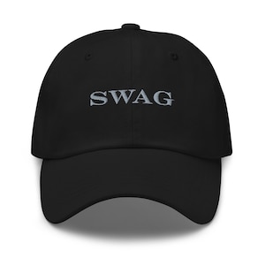 May include: Black baseball cap with the word "SWAG" embroidered in silver thread across the front. The cap has a curved brim and a structured fit. A classic, stylish accessory.