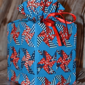 Capa para caixa de lenços de papel feita à mão com desenho de cata-vento vermelho, branco e azul