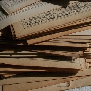 Könnte beinhalten: Ein Stapel alter, vergilbter Papierdokumente mit französischem Text. Das oberste Dokument trägt den Titel "LANGUE-DE-CARPETTE-LARRON" und die Nummer "353".