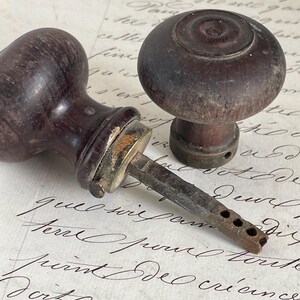 Par de manijas de puerta redondas de madera estilo francés antiguo con pomos de puerta y collares de latón.