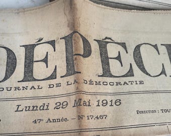 May include: Close-up of a vintage newspaper fragment with the headline "DEPECHE" in large, bold letters. The date "Lundi 29 Mai 1916" is visible, along with other text. The paper has a faded, aged appearance.