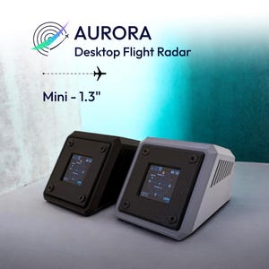 Può includere: Due dispositivi Aurora Desktop Flight Radar Mini da 1.3 pollici. Un'unità è nera e l'altra è grigio chiaro. Ciascuno presenta uno schermo quadrato che mostra dati radar, fissato da quattro viti angolari e feritoie di ventilazione.