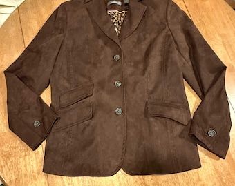 May include: A dark brown blazer with a textured finish, featuring a notched lapel, three front buttons, two flap pockets, and long sleeves with buttoned cuffs. The interior lining displays a brown and black leopard print pattern.