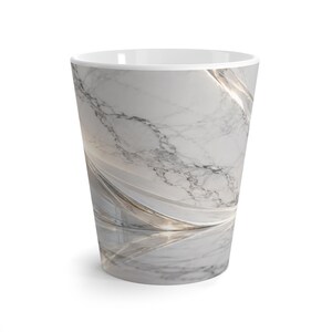 Puede incluir: Un vaso cónico con un patrón de mármol blanco y gris con acentos dorados metálicos en espiral. El vaso tiene un acabado liso y brillante con un borde interior blanco, mostrando una estética moderna con líneas fluidas.