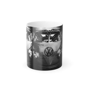 Peut inclure: Un mug en céramique blanche orné d'une impression photographique en noir et blanc de l'avant d'un bus Volkswagen classique. Le design présente le logo VW emblématique centré sur le panneau avant et le mot "Everything" écrit en lettres cursives.
