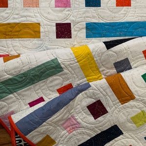 modern quilt pattern made up of colorful squares and rectangles