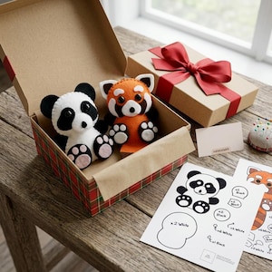 May include: A felt panda and a felt red panda plush toy inside an open cardboard box with a red plaid pattern. A separate gift box with a red ribbon, a small blank card labelled valanziakh, a pincushion, and printed craft pattern sheets.