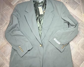 May include: A sage green blazer featuring a single gold-tone button closure, notched lapels, and long sleeves with four small gold-tone buttons on each cuff. The interior is lined with a dark olive green fabric and includes a white brand tag.