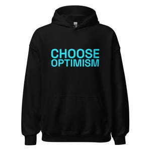 May include: A black hooded sweatshirt featuring the text CHOOSE OPTIMISM printed in bright cyan blue across the chest. The garment includes a drawstring hood, long sleeves with ribbed cuffs, a front kangaroo pocket, and a ribbed hem.