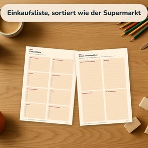 May include: Two white paper sheets with printed grids and text, including the titles Einkaufsliste and Unser Ideenspeicher. The sheets feature organised sections with checkboxes and lines for writing lists, presented on a wooden surface.