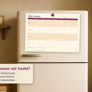 May include: A weekly meal planner chart titled Unser Essensplan with a purple header and grid layout for seven days, featuring rows for breakfast, lunch, dinner, and snacks, attached to a refrigerator with a purple circular magnet at the top.