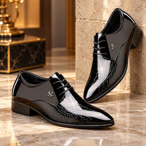 May include: A pair of black dress shoes with a glossy finish and a textured, scale-like pattern on the sides. Each shoe features a pointed toe, black laces, and a small, silver-toned cross-shaped emblem on the upper panel near the eyelets.
