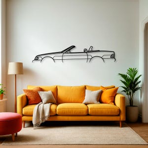 Può includere: Un pezzo di arte da parete in metallo nero che presenta il contorno minimalista di un'auto decappottabile. Il design lineare cattura il profilo laterale del veicolo, inclusi il parabrezza, i sedili e la carrozzeria, montato come una silhouette.