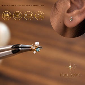 May include: A 14K gold threadless push-pin stud earring featuring a cluster design with a white pearl, a blue gemstone, and two clear lab-grown diamonds. The jewelry is marked with text including 14K GOLD, LAB-GROWN DIAMOND, and 2026 POLARIS.