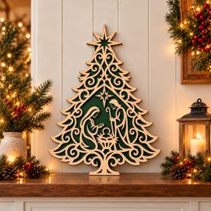 May include: A laser-cut wooden Christmas tree wall decoration featuring a dark green background and a cutout nativity scene with Mary, Joseph, and the infant Jesus. The tree is topped with a star and has intricate scrollwork patterns.