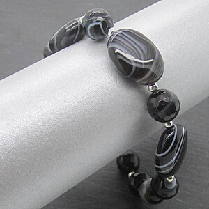 Puede incluir: Pulsera de &aacute;gata negra y blanca con cuentas de plata. La pulsera est&aacute; hecha con cuentas ovaladas y redondas.