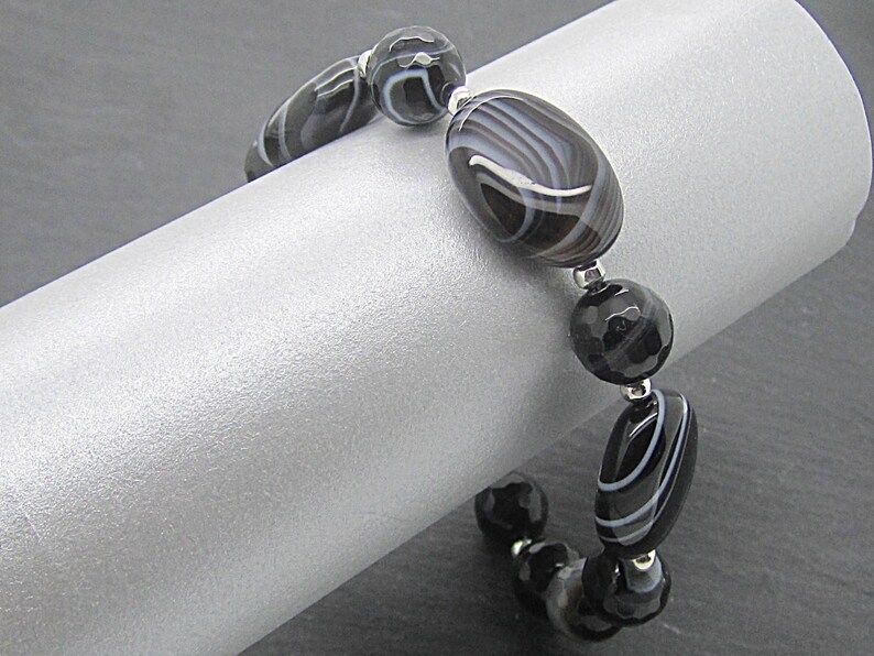Puede incluir: Pulsera de &aacute;gata negra y blanca con cuentas de plata. La pulsera est&aacute; hecha con cuentas ovaladas y redondas.