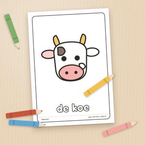 Puede incluir: Una p&aacute;gina rectangular blanca para colorear con una cabeza de vaca de dibujos animados con cuernos amarillos, un hocico rosa y manchas negras. El texto 'de koe' est&aacute; impreso en la parte inferior. Rodeada por cinco l&aacute;pices de colores.