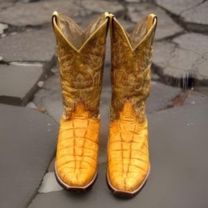 Pode incluir: Um par de botas de cowboy amarelas com um padrão texturizado semelhante a escamas no pé e um cano alto com bordados tonais intrincados. As botas apresentam um design de bico fino e uma gola distinta em forma de V no topo do cano.