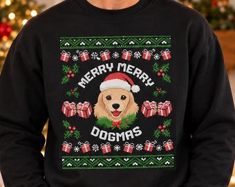 May include: A black crewneck sweatshirt featuring a graphic print of a golden dog wearing a red and white Santa hat. The design includes green holly, red berries, red gift boxes, and the text MERRY MERRY DOGMAS in white lettering.