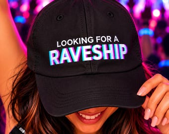 May include: A black baseball cap featuring the white text "LOOKING FOR A" above the word "RAVESHIP" in a stylized, multi-layered font with cyan, magenta, and white color shifts, creating a distinct three-dimensional visual effect.