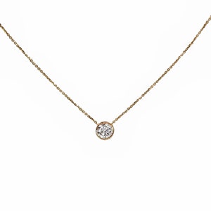 May include: A delicate gold chain necklace with a single round diamond pendant.