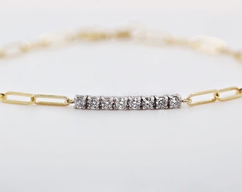 May include: A gold chain bracelet with a row of small, clear diamonds.