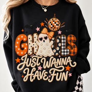 Może przedstawiać: Czarna bluza z grafiką z napisem GHOULS JUST WANNA HAVE FUN. Wzór przedstawia ducha w okularach w kształcie serc i kokardzie, kulę dyskotekową, nietoperze oraz gwiazdki, z literami w pomarańczowe, białe i czarne wzory.