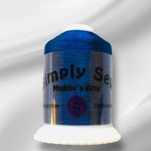 Peut inclure: Une bobine de fil à broder bleu avec le texte "Simply Sew Maddie's Attic" sur l'étiquette.